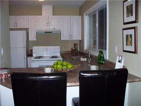 A kitchen with white cabinets and a granite countertop.