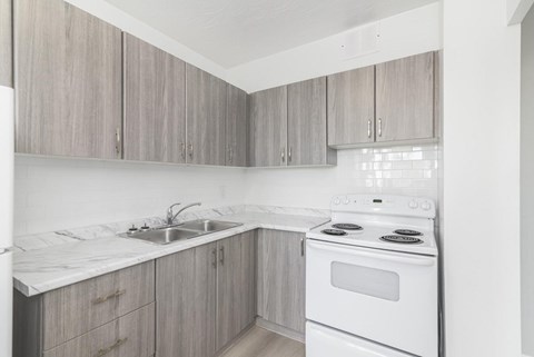 A kitchen with a white stove and sink.
