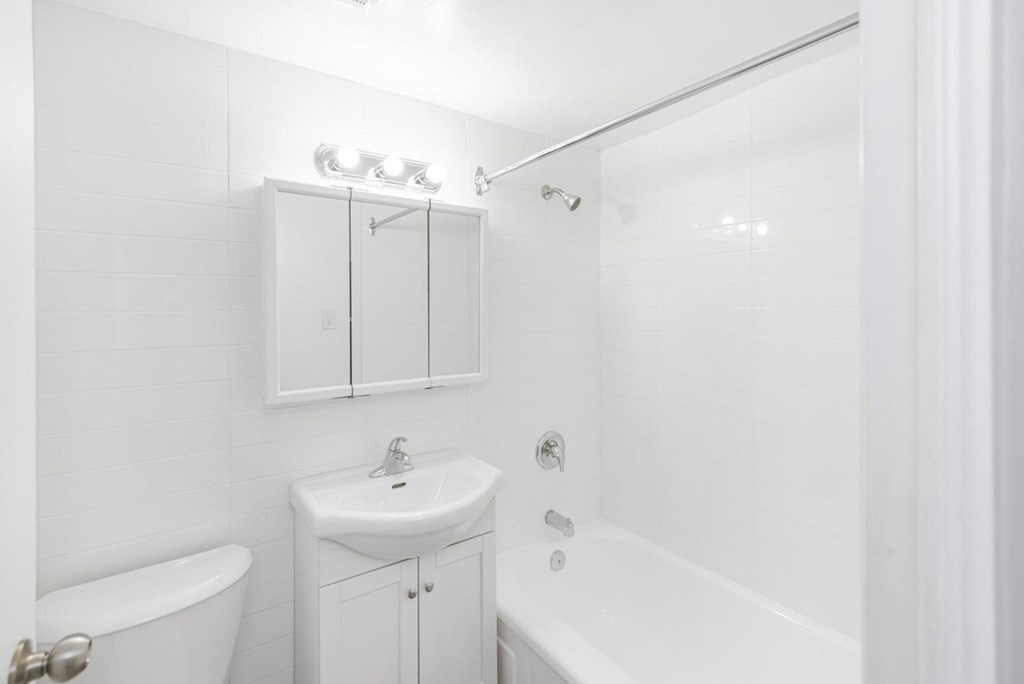 A white bathroom with a sink, toilet, and bathtub.