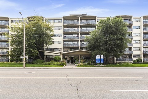 A large apartment complex with a crack in the road in front.