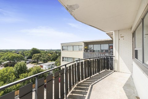 A balcony with a metal railing and steps leading to a building.