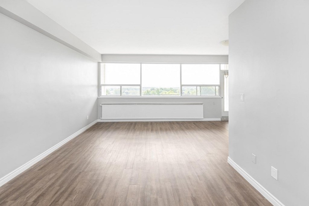 A room with wooden flooring and a large window.