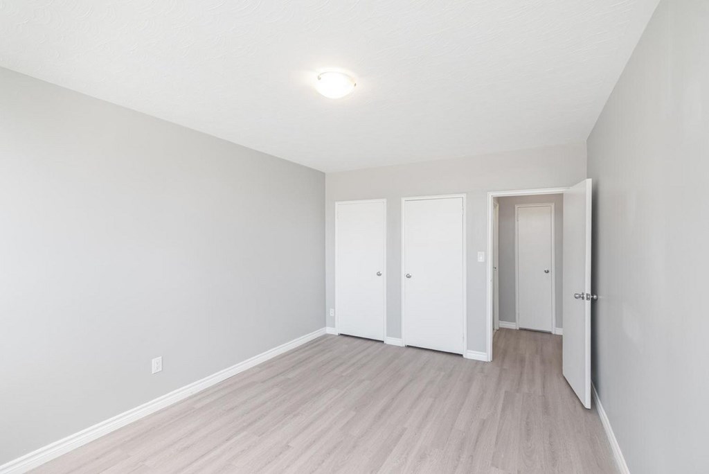 A room with a white door and a light on the ceiling.