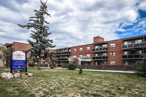 A sign in front of a building that says Centennial Court.