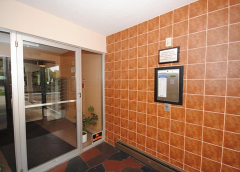 A wall of orange tiles with a black box on it.