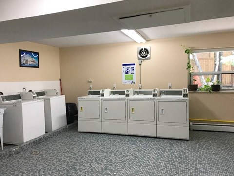 A row of white machines are lined up in a room.