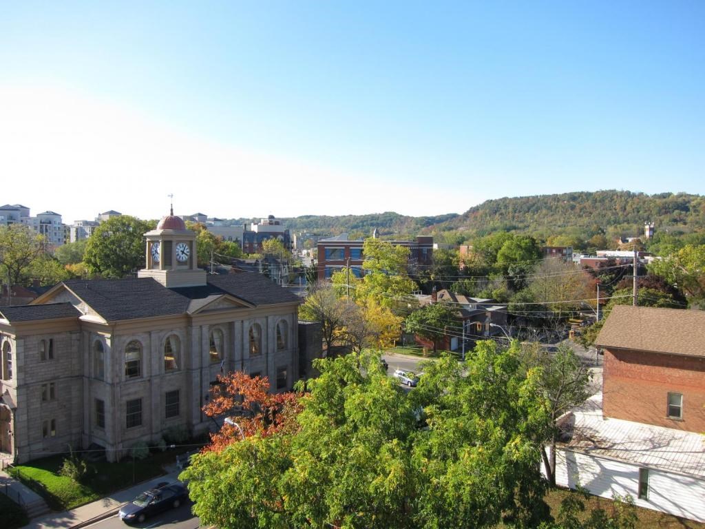 A clock tower stands atop a building in a town.