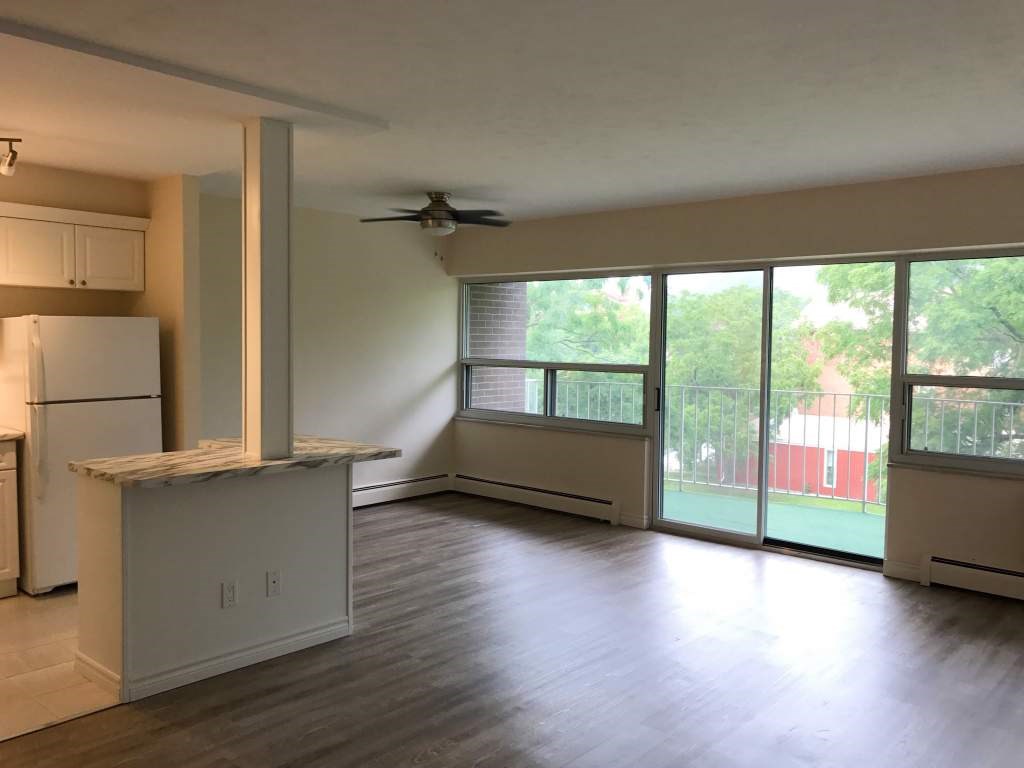 A kitchen with a refrigerator, cabinets, and a countertop.