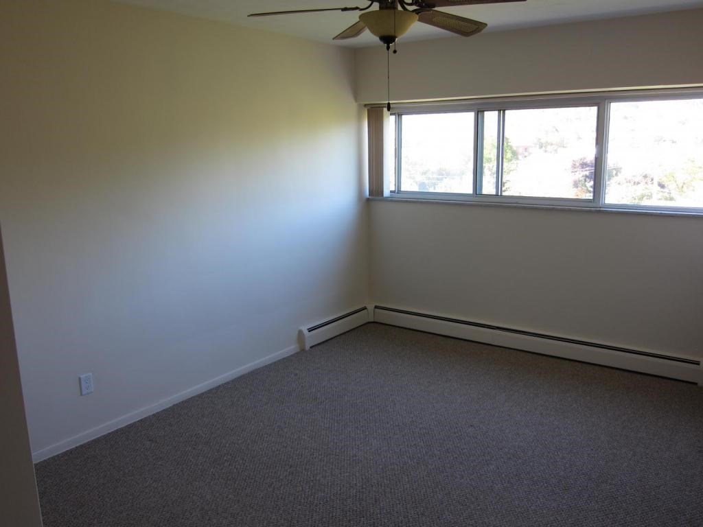 A room with a ceiling fan and a window.