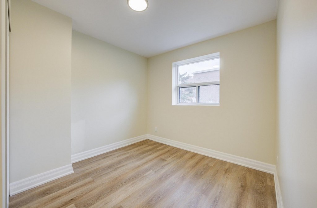 A room with a window and wooden flooring.