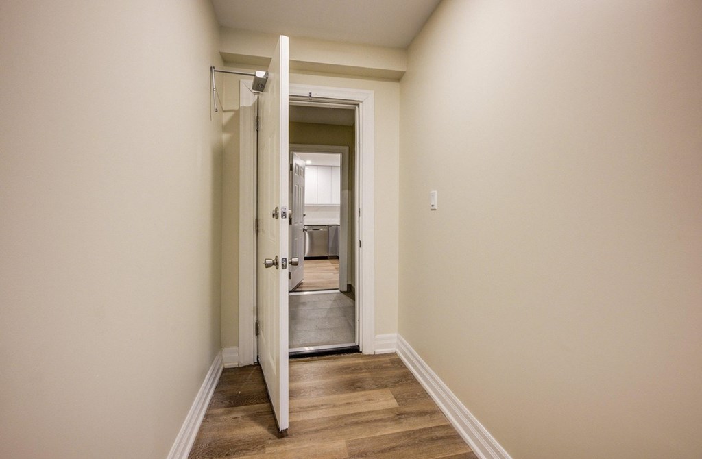 A hallway with a door open to a bathroom.