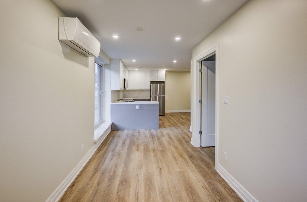 A long hallway with a kitchen at the end.