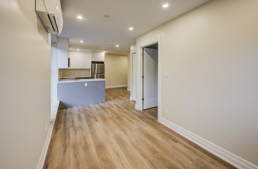 A kitchen with a wooden floor and white walls.