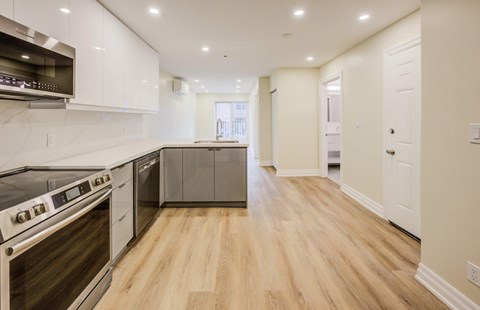 A modern kitchen with white cabinets and stainless steel appliances.