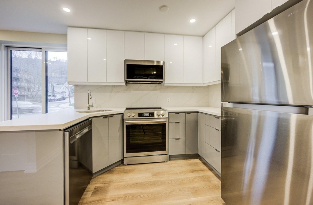 A modern kitchen with stainless steel appliances and white cabinets.