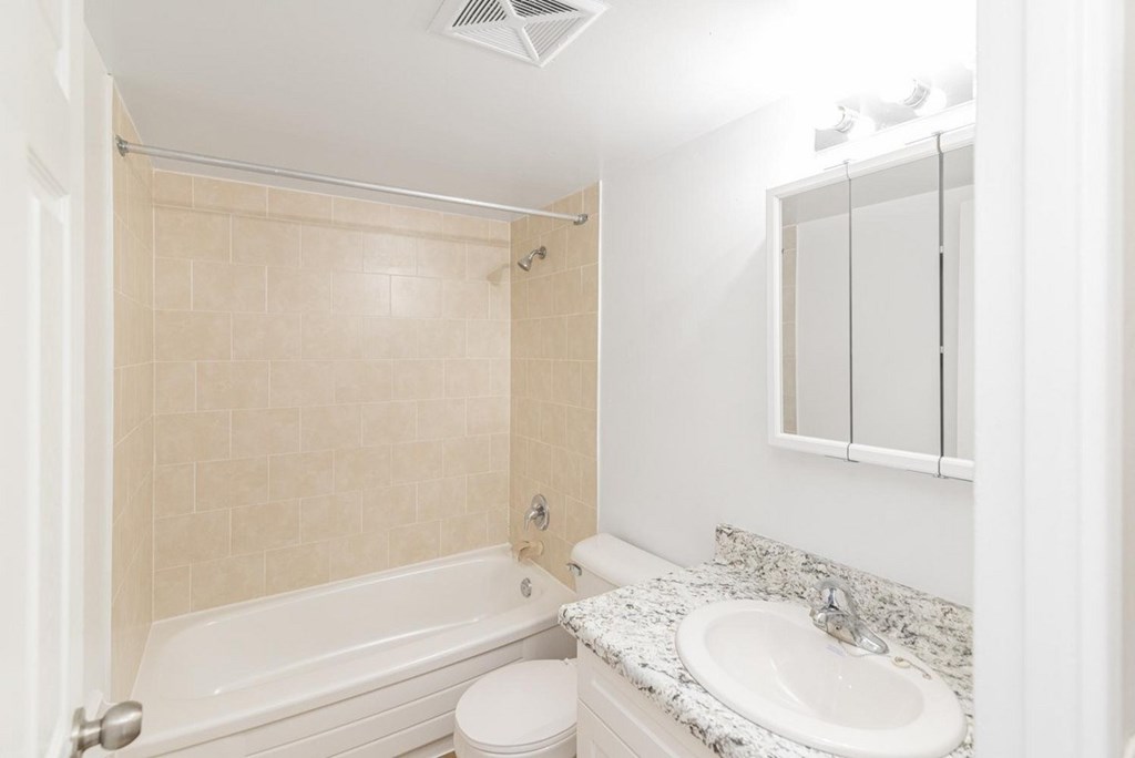 A white bathroom with a toilet, sink, and bathtub.