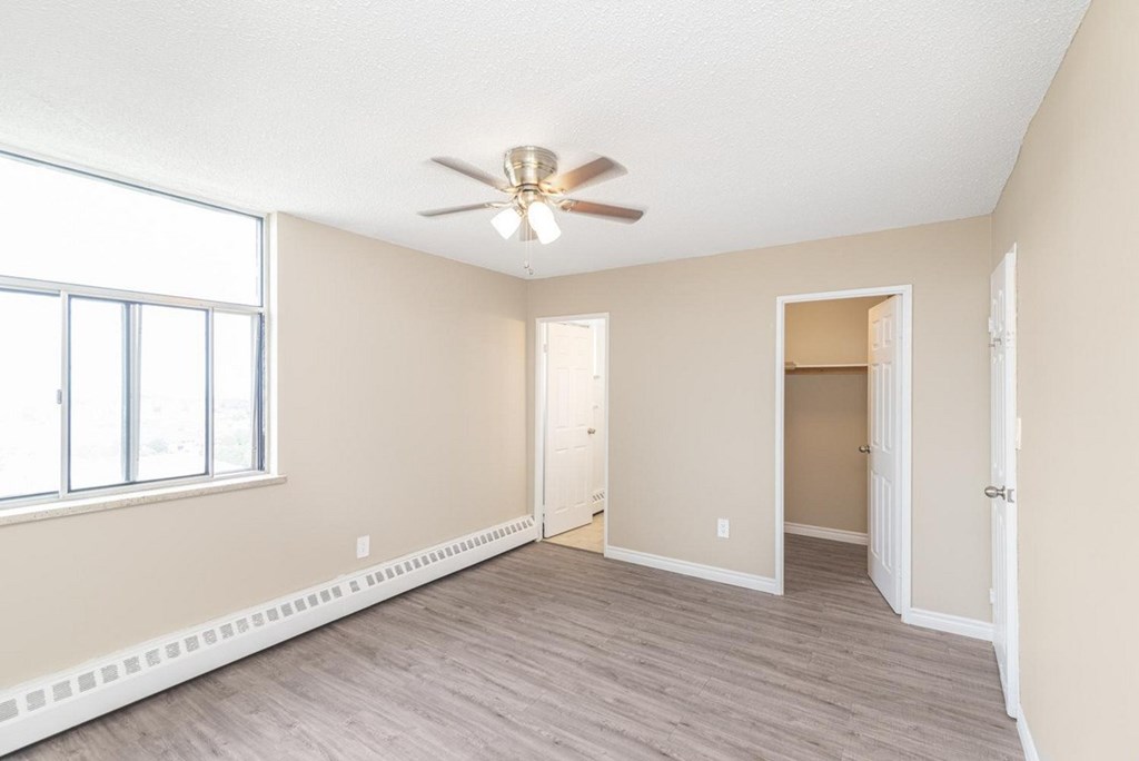 A room with a ceiling fan and a window.