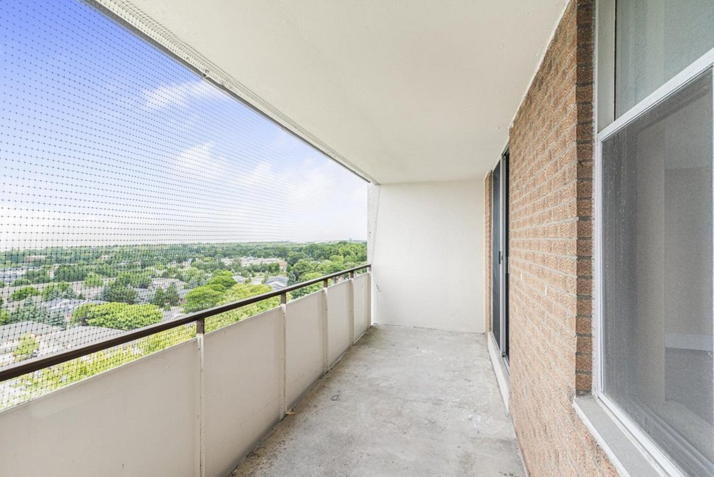 A balcony with a view of a green landscape.