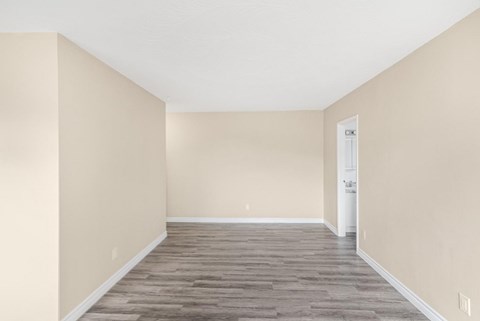 A room with wooden flooring and a white door.