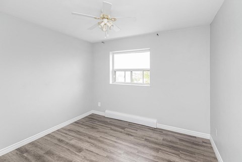 A room with a ceiling fan and a window.