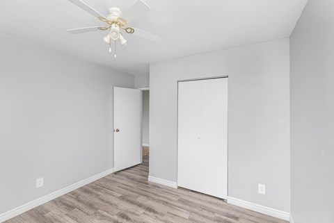 A room with a ceiling fan and two doors.