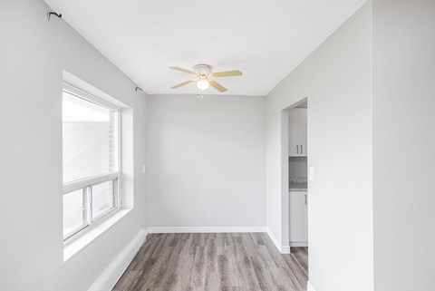 A room with a ceiling fan and a window.
