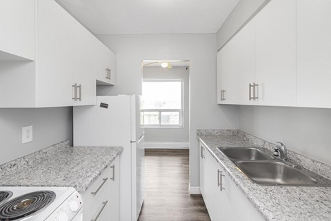 A kitchen with white cabinets and a granite countertop.