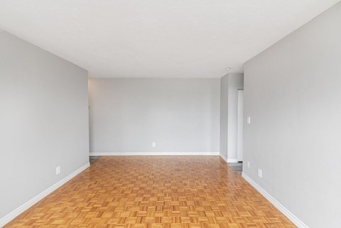 A room with wooden flooring and white walls.