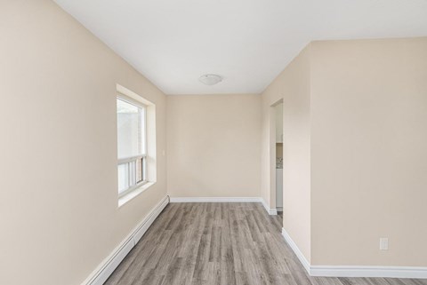 A room with a window and wooden flooring.