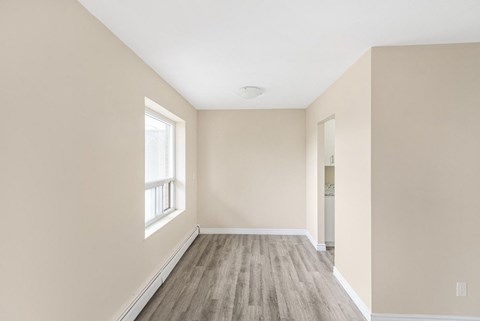 A room with a window and wooden flooring.