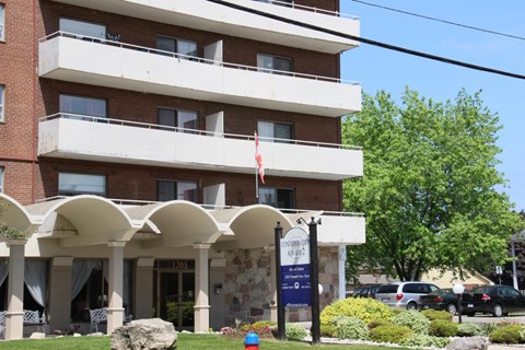 A building with a sign that says "Welcome to Evergreen Apartments" in front of it.