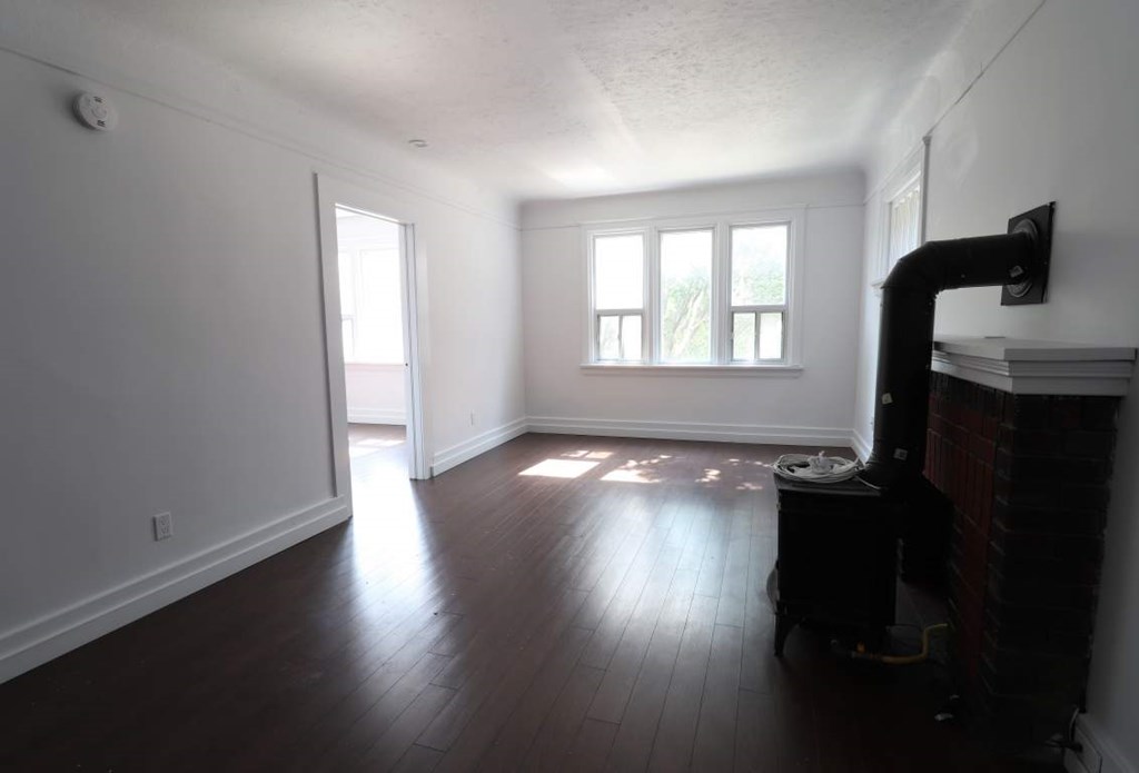 A room with a fireplace and a television on the wall.