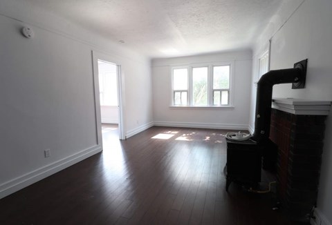 A room with a fireplace and a television on the wall.