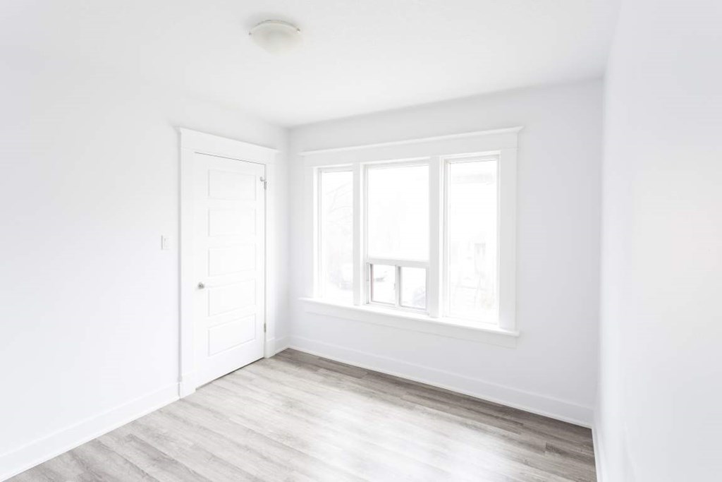 A white room with a door and a window.