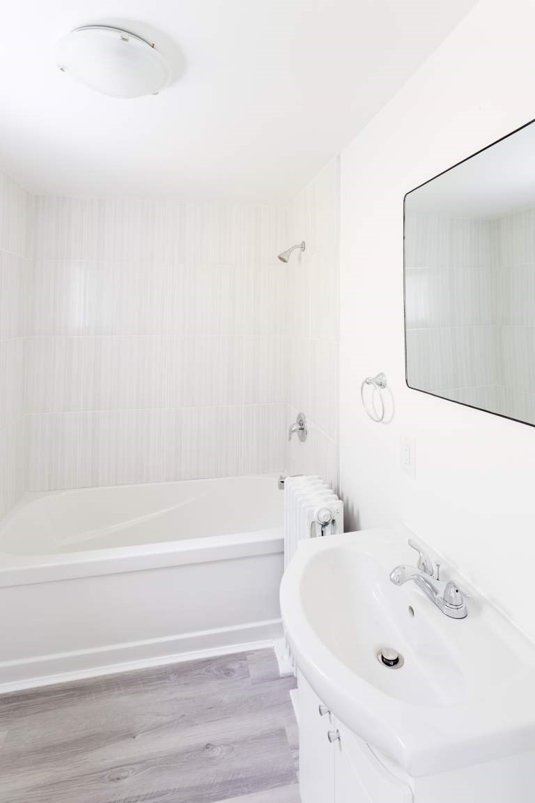 A white bathroom with a tub and sink.