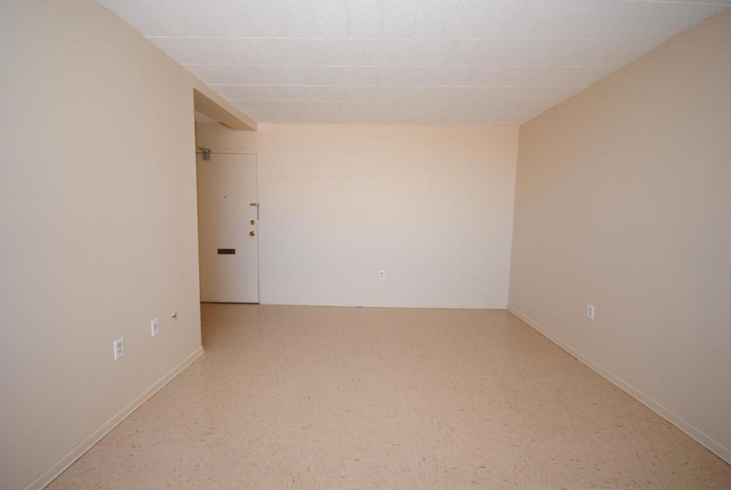 A room with a door and a wall socket.