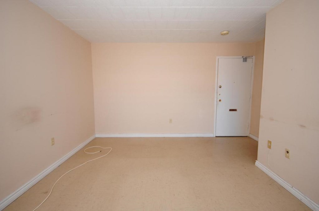 A room with a white door and a white baseboard heater.
