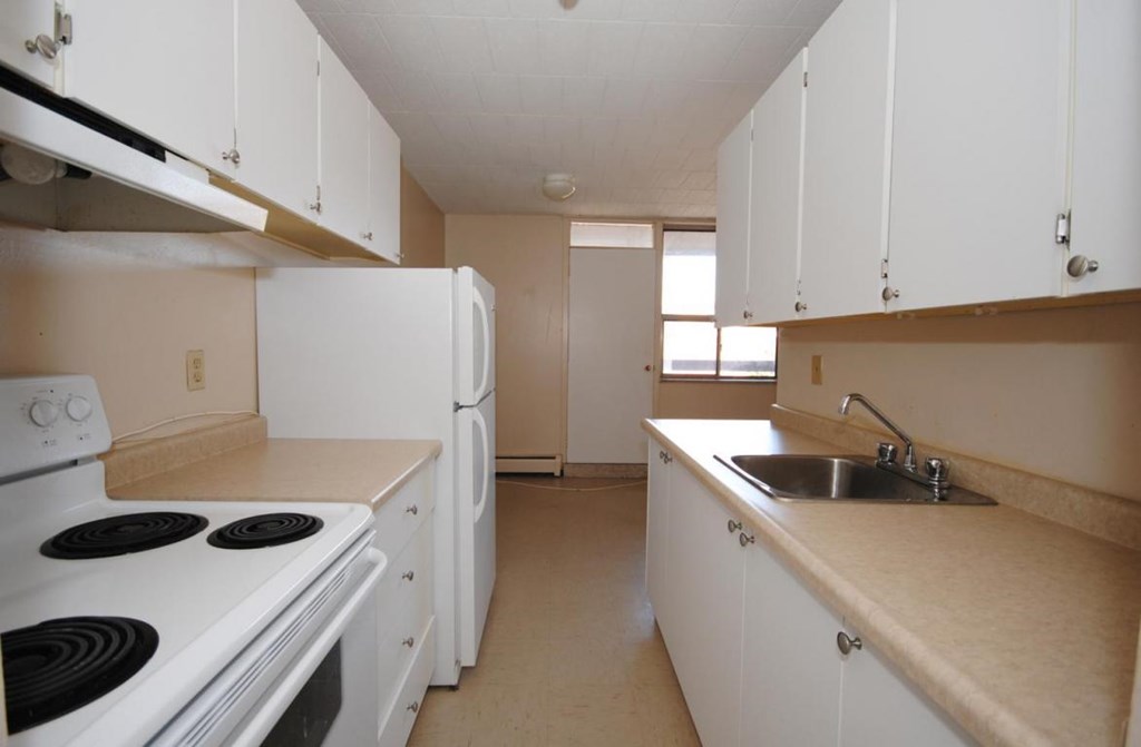 A kitchen with white appliances and cabinets.