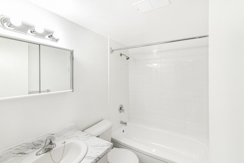 A white bathroom with a sink, toilet, and bathtub.