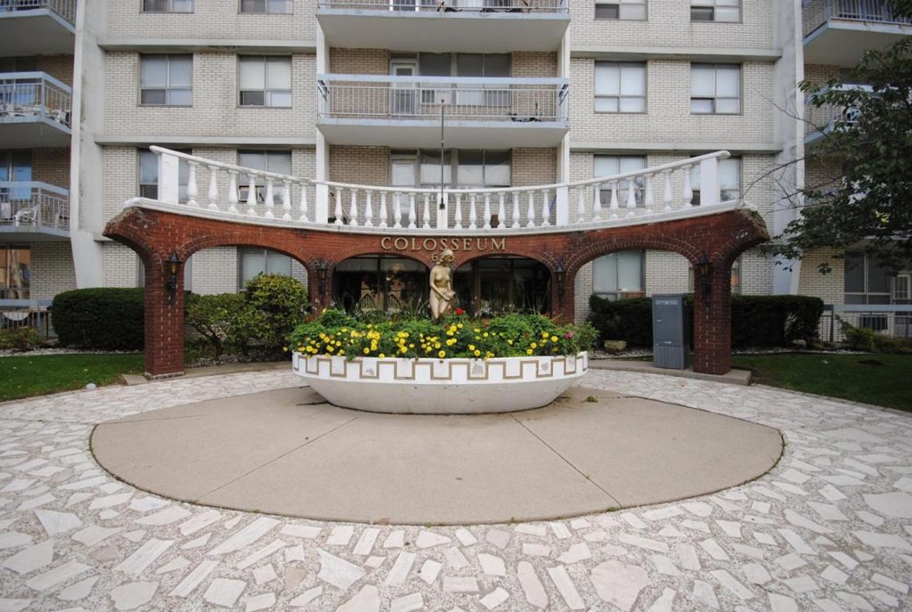 A courtyard with a fountain and a sign that says "GOLOSUMM".