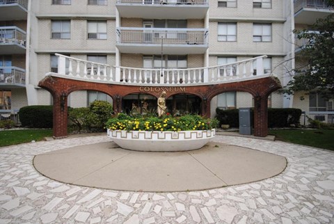 A courtyard with a fountain and a sign that says "GOLOSUMM".