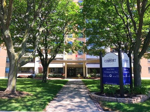A Comfort senior living facility is surrounded by trees.