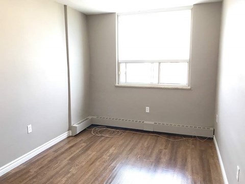 A room with a window and a radiator on the floor.