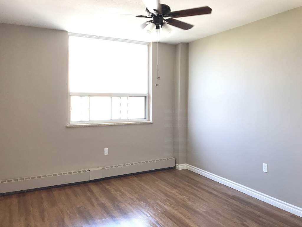 A room with a ceiling fan and a window.