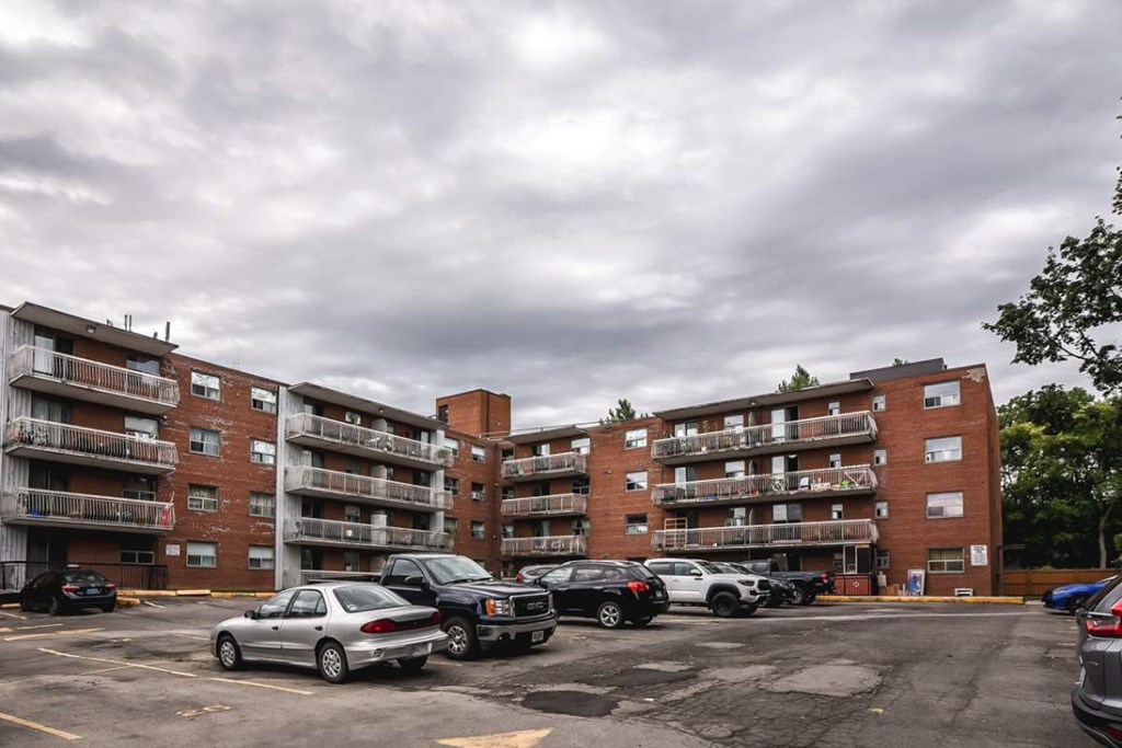 A parking lot with cars and apartment buildings in the background.