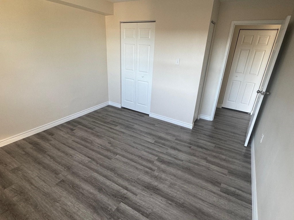 A room with a grey floor and two white doors.