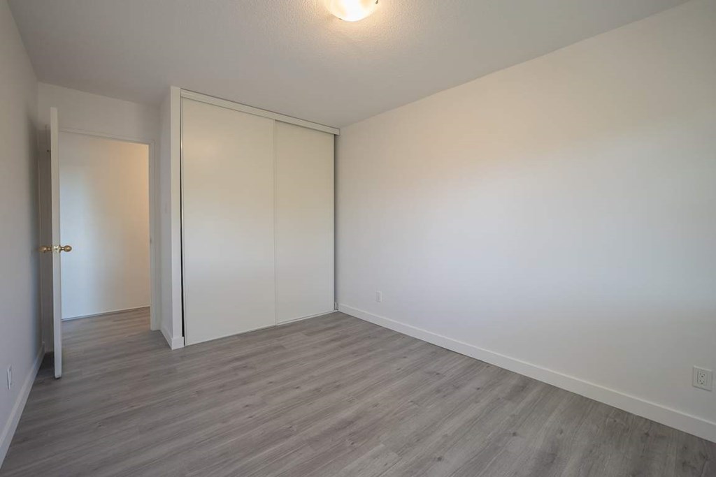 A room with a white door and a grey floor.