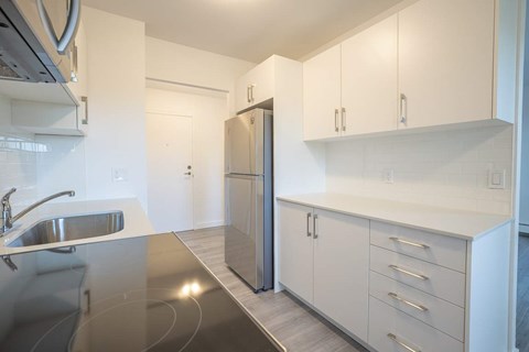 A modern kitchen with a stainless steel sink and refrigerator.