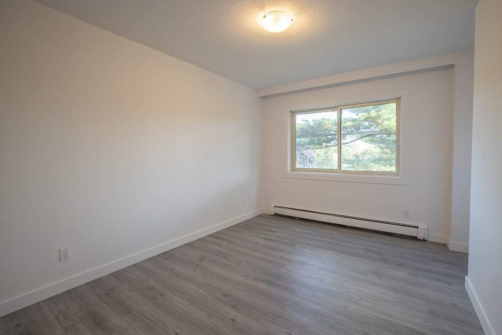 A room with a window and a grey floor.