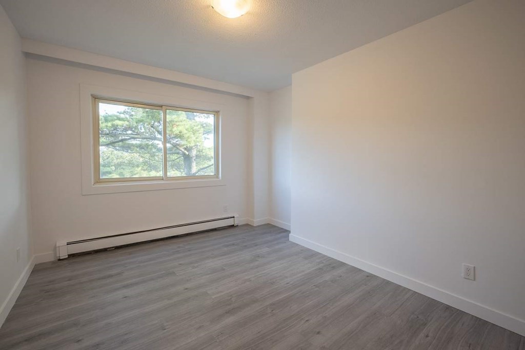 A room with a window and a heating system under the window.